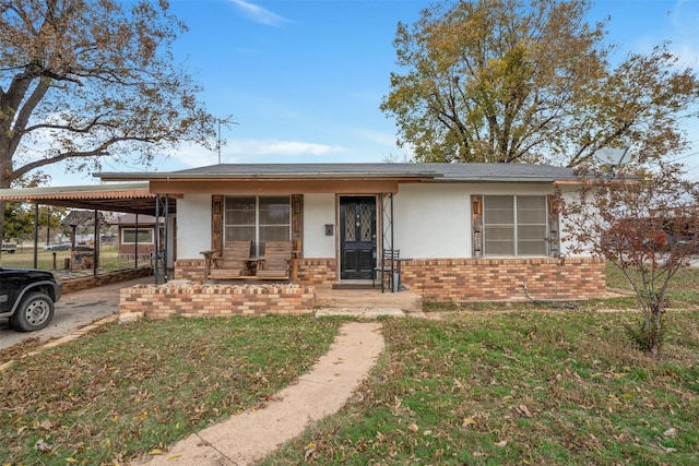 view of front of house with a front yard and a carport