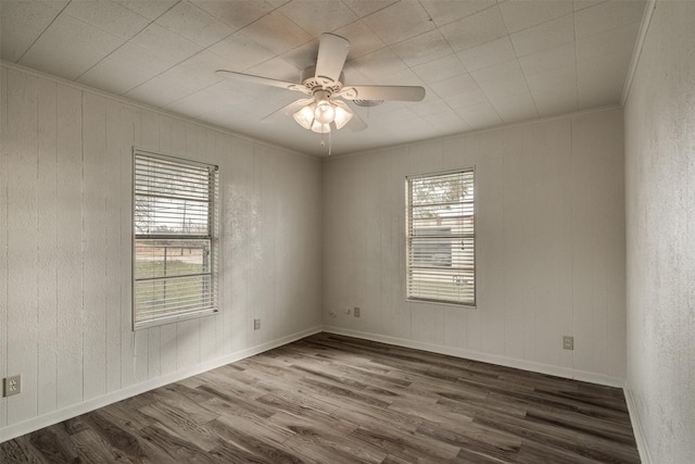 spare room featuring crown molding, ceiling fan, and dark wood-type flooring