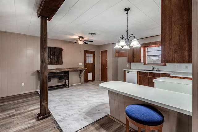 kitchen with dishwasher, ceiling fan with notable chandelier, light hardwood / wood-style flooring, and sink