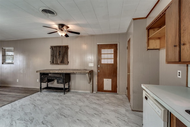 kitchen featuring ceiling fan, wooden walls, white dishwasher, and light hardwood / wood-style flooring