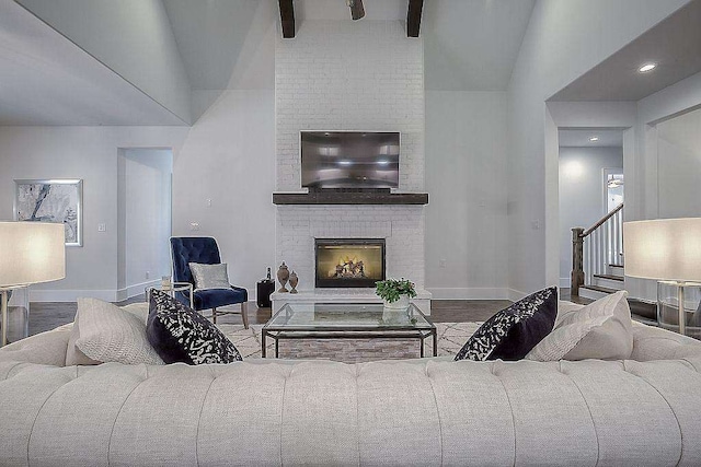 living room featuring a fireplace, beamed ceiling, wood-type flooring, and high vaulted ceiling