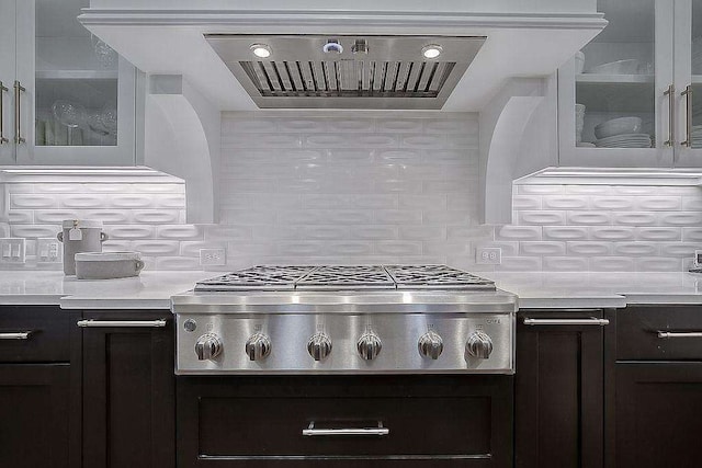 kitchen featuring decorative backsplash, cooktop, dark brown cabinets, and extractor fan