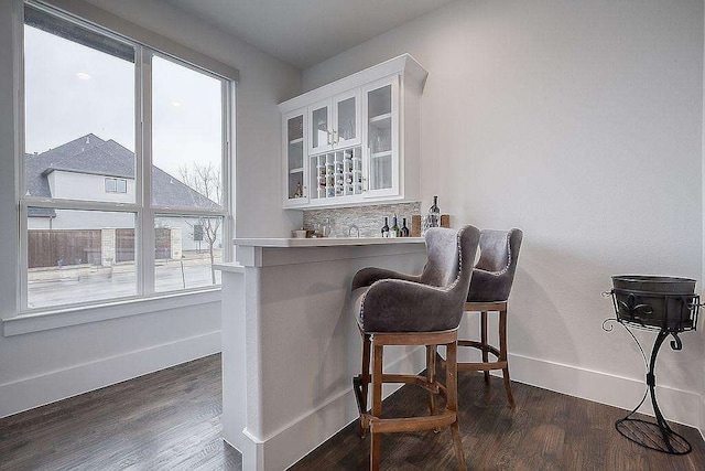 bar featuring white cabinetry and dark hardwood / wood-style flooring