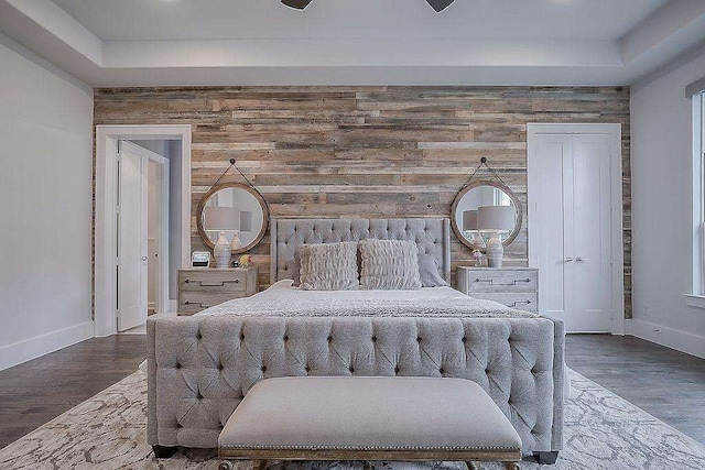 bedroom featuring ceiling fan, wood-type flooring, and wooden walls