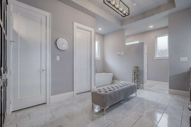 bathroom with a raised ceiling and tile patterned flooring