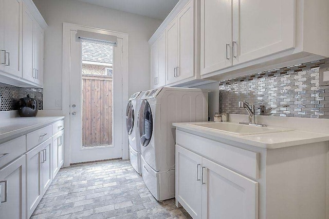 washroom featuring cabinets, washer and clothes dryer, and sink