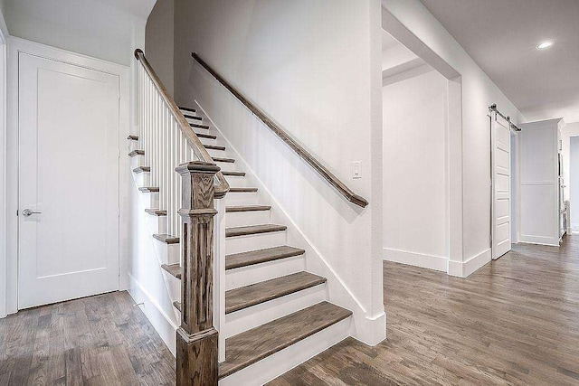 staircase featuring hardwood / wood-style floors and a barn door