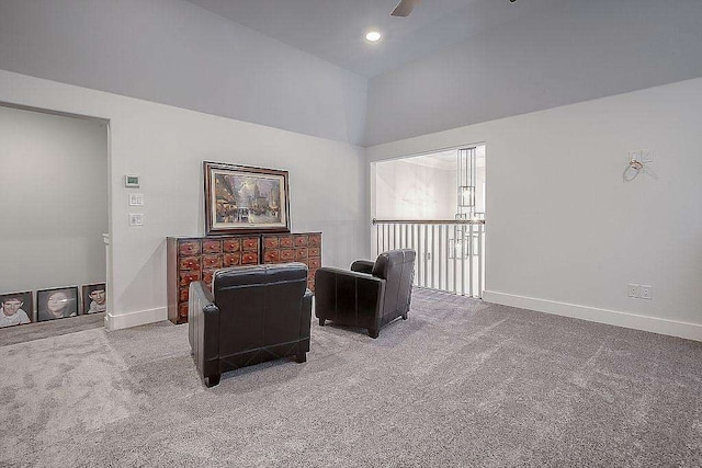 living area with ceiling fan, carpet, and lofted ceiling