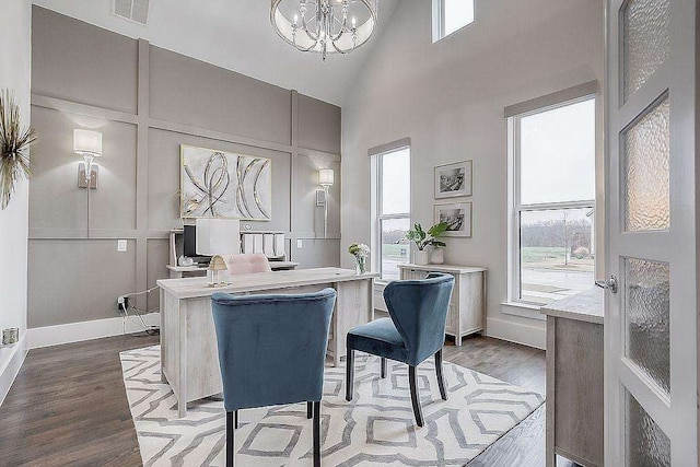 dining space with high vaulted ceiling, wood-type flooring, and an inviting chandelier