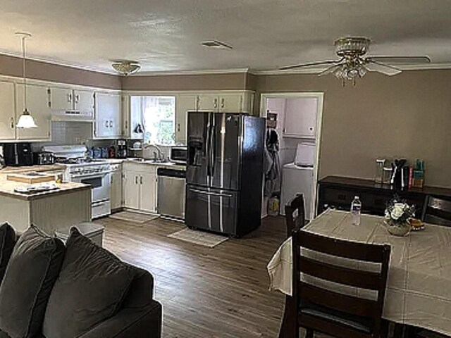 kitchen featuring white cabinetry, gas range gas stove, stainless steel dishwasher, pendant lighting, and black fridge with ice dispenser