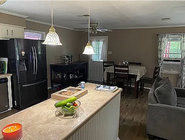 kitchen with black refrigerator with ice dispenser, plenty of natural light, dark wood-type flooring, and ornamental molding