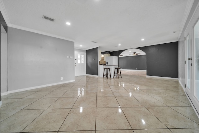 tiled spare room featuring ceiling fan, a textured ceiling, and ornamental molding