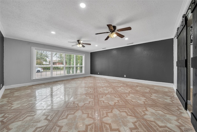 empty room featuring a textured ceiling, a barn door, ceiling fan, and crown molding