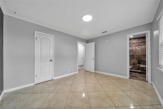 unfurnished bedroom with a fireplace, ensuite bathroom, crown molding, and light tile patterned floors