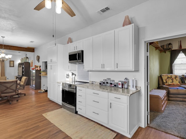 kitchen with white cabinets, light wood-type flooring, decorative light fixtures, and appliances with stainless steel finishes