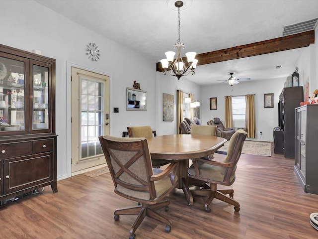 dining area with beamed ceiling, ceiling fan with notable chandelier, and dark wood-type flooring