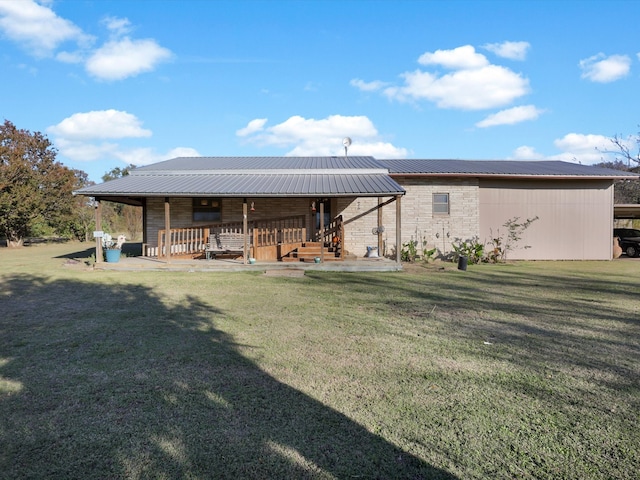 rear view of house featuring a yard and a porch