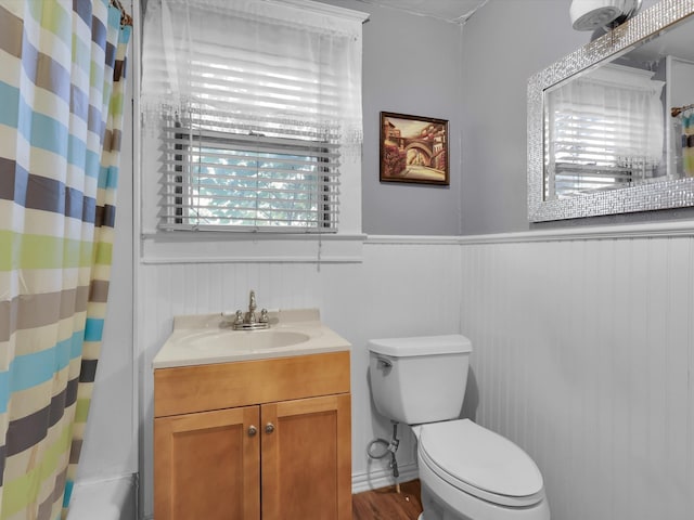 bathroom featuring vanity, hardwood / wood-style flooring, toilet, and curtained shower