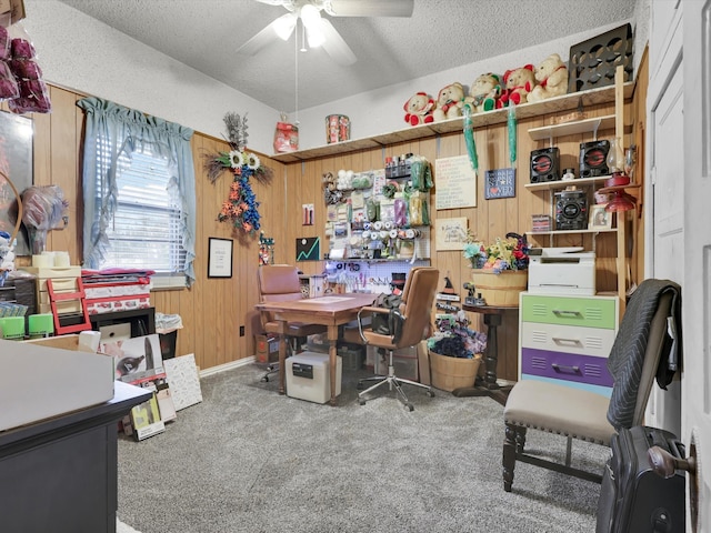 carpeted office featuring a textured ceiling, ceiling fan, and wooden walls