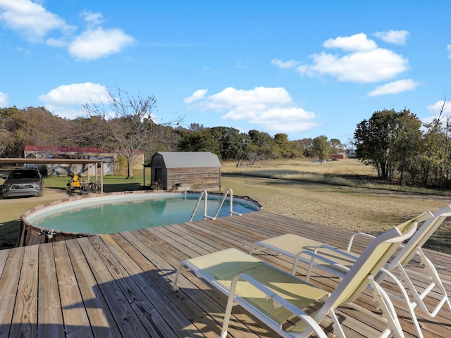 view of swimming pool with a storage shed and a deck