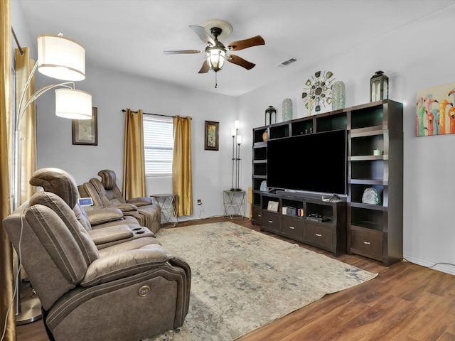 living room featuring ceiling fan and dark wood-type flooring