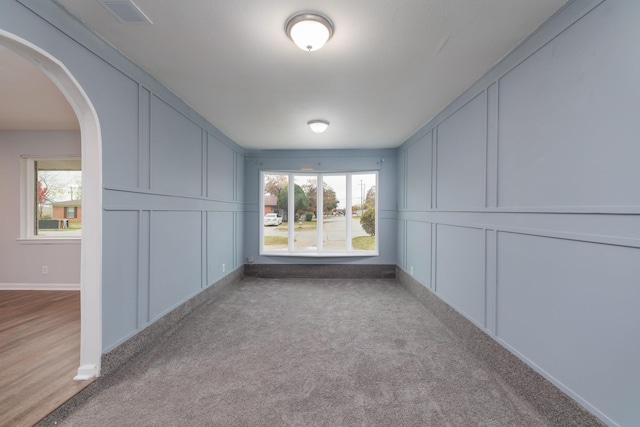 empty room with light colored carpet and a wealth of natural light