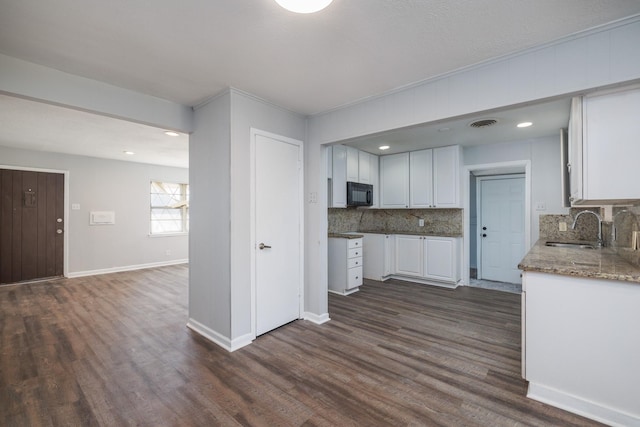 kitchen with white cabinets, backsplash, dark hardwood / wood-style flooring, and sink