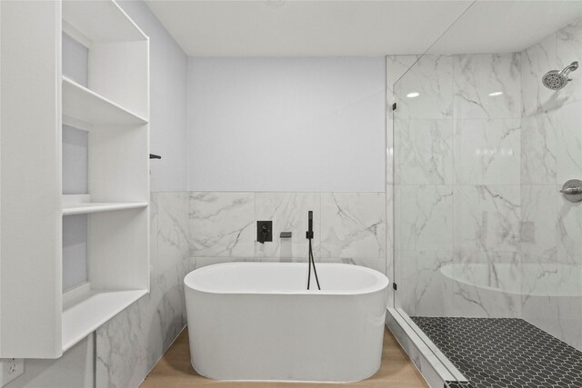 bathroom featuring separate shower and tub, wood-type flooring, and tile walls