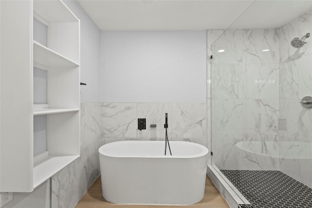 bathroom with hardwood / wood-style flooring, independent shower and bath, and tile walls