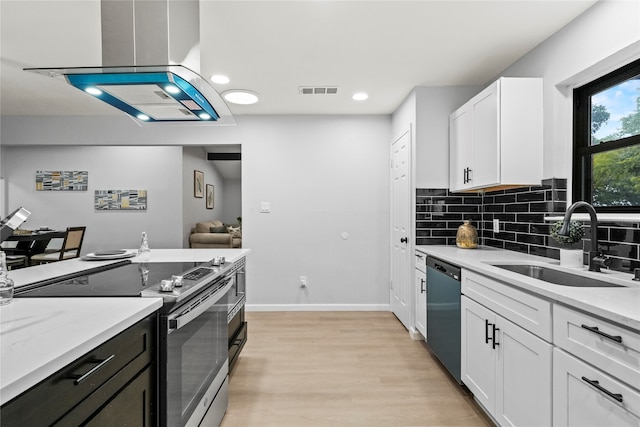 kitchen with light stone countertops, sink, stainless steel appliances, light hardwood / wood-style flooring, and white cabinets