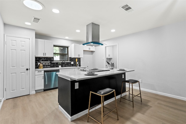 kitchen featuring dishwasher, a breakfast bar, white cabinets, light wood-type flooring, and island exhaust hood