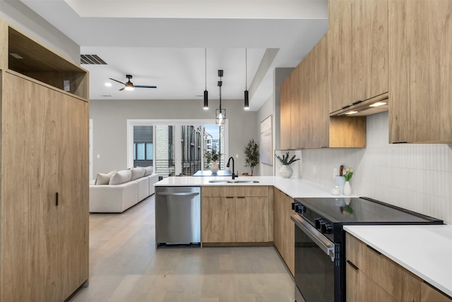 kitchen with ceiling fan, sink, stainless steel appliances, decorative light fixtures, and light wood-type flooring