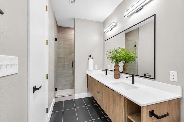 bathroom with tile patterned flooring, vanity, and a shower with door