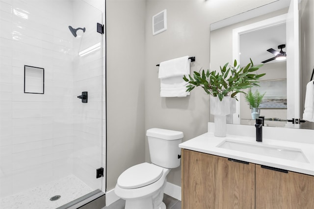 bathroom featuring vanity, ceiling fan, toilet, and a shower with door