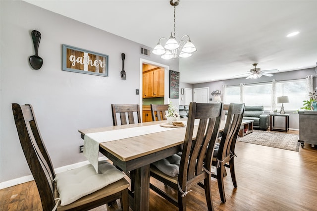 dining space featuring ceiling fan with notable chandelier and light wood-type flooring