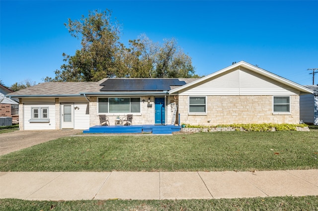 ranch-style home featuring central air condition unit, a front lawn, and solar panels