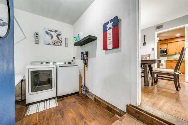 laundry room with washer and clothes dryer and dark hardwood / wood-style flooring