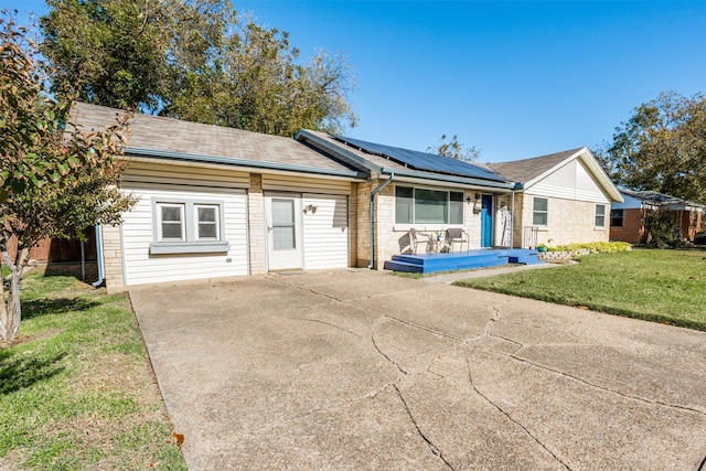 ranch-style home with solar panels, a porch, and a front yard