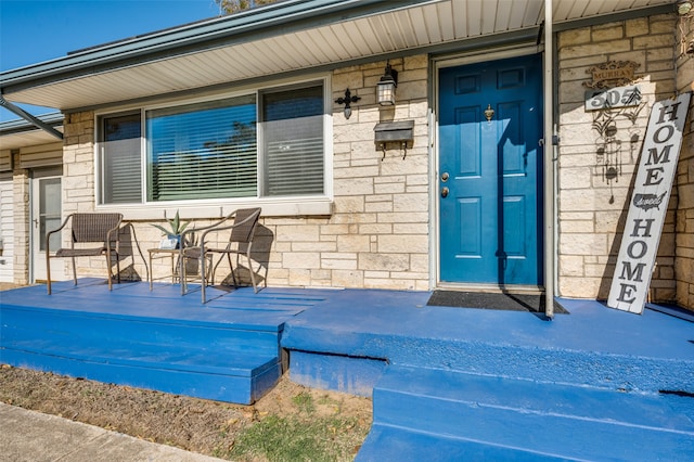 view of exterior entry featuring covered porch