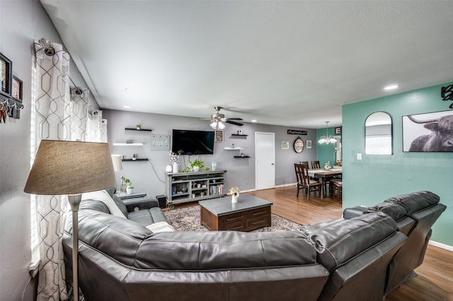 living room featuring hardwood / wood-style floors and ceiling fan with notable chandelier