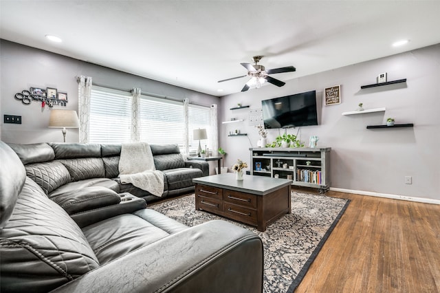 living room featuring dark hardwood / wood-style flooring and ceiling fan