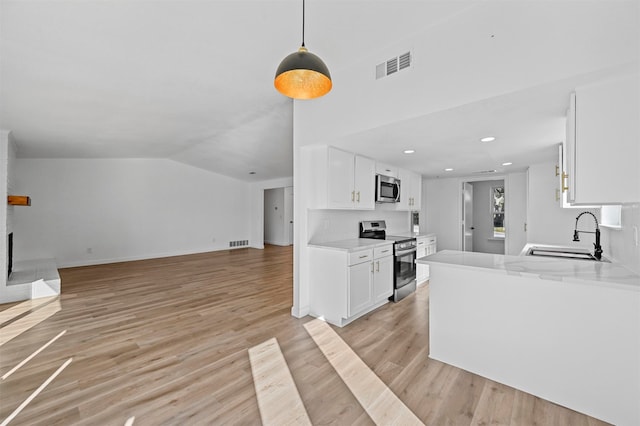 kitchen with white cabinetry, sink, stainless steel appliances, and light hardwood / wood-style flooring