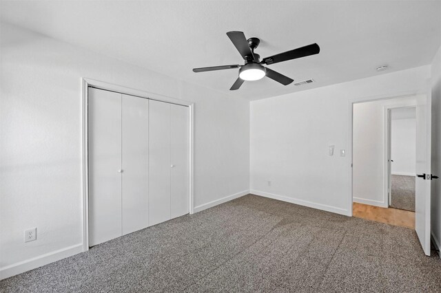 unfurnished bedroom featuring ceiling fan, a closet, and carpet floors