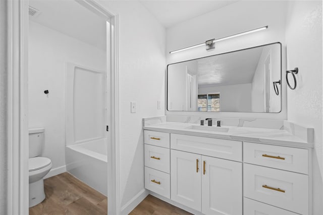 full bathroom with washtub / shower combination, hardwood / wood-style floors, vanity, and toilet