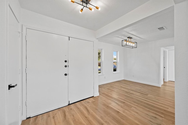 entrance foyer featuring a textured ceiling and light wood-type flooring