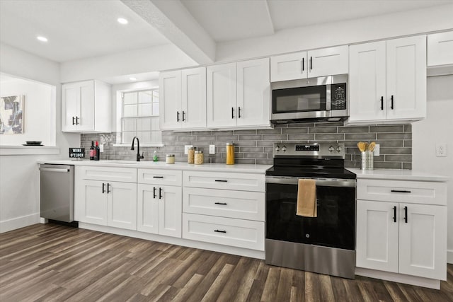 kitchen featuring sink, dark wood-type flooring, white cabinetry, stainless steel appliances, and tasteful backsplash