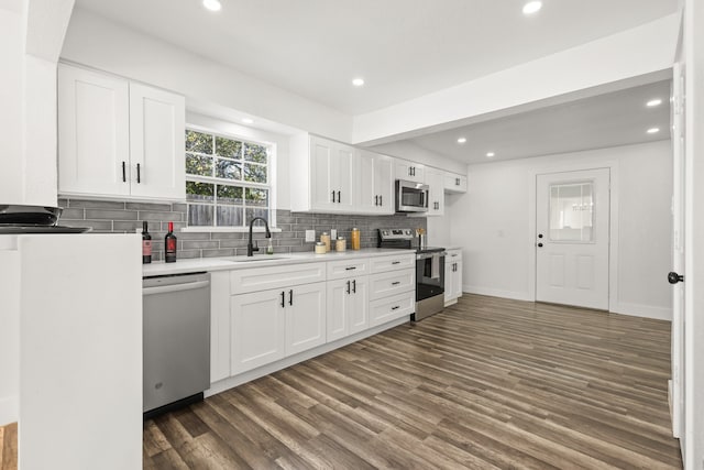 kitchen featuring tasteful backsplash, stainless steel appliances, sink, white cabinets, and dark hardwood / wood-style floors