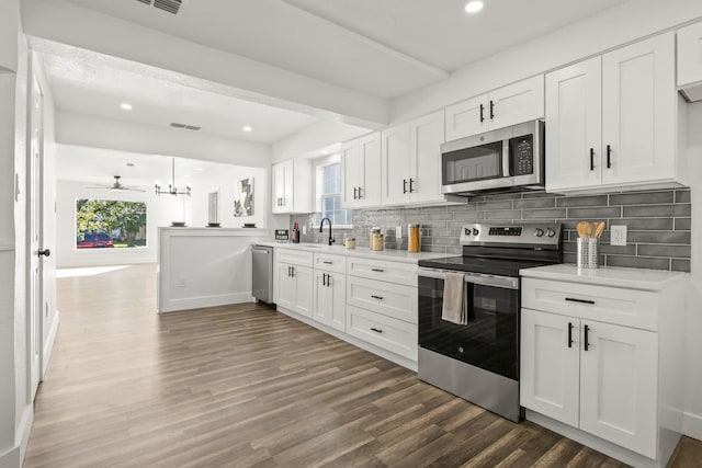 kitchen featuring decorative backsplash, white cabinetry, ceiling fan, and stainless steel appliances