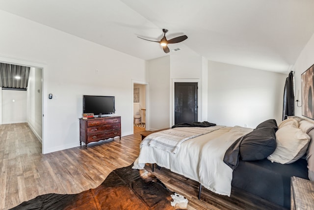 bedroom with hardwood / wood-style flooring, ceiling fan, lofted ceiling, and connected bathroom