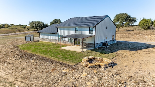 rear view of property featuring a fire pit and a patio area